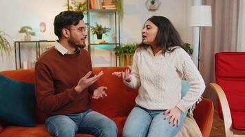 verärgert jung indisch Paar streiten Kampf während Sitzung auf Sofa im Leben Zimmer beim heim. Scheidung von Familie. vielfältig enttäuscht Freundin und Freund schreien beim jeder andere auf Couch im Wohnung. video