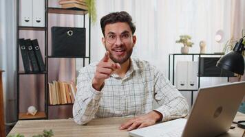 I choose you. Young Arabian businessman programmer software developer working on office laptop pointing to camera, looking with happy expression, making choice showing direction. Indian freelancer guy video
