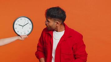 indiano giovane uomo con ansia controllo tempo su orologio, in esecuzione in ritardo per opera, essere nel ritardo, Scadenza. arabo tipo guardare a ora, minuti, preoccupante per essere puntuale isolato su studio arancia sfondo video