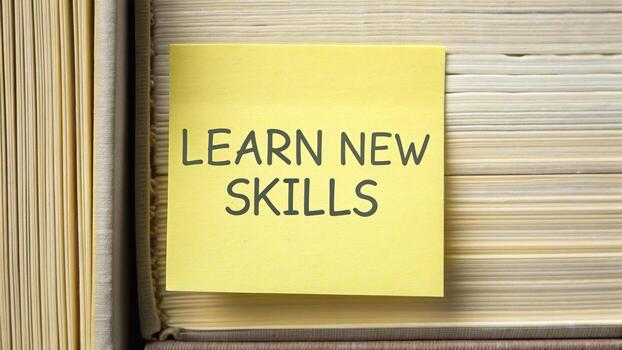 Sticky note on book page emphasizes importance of education and personal growth, encouraging individuals to learn new skills for self improvement and development photo