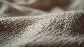 invecklad närbild av en naturlig beige vävd tyg, highlighting de grov än organisk textur och detaljerad tråd mönster, perfekt som en rustik bakgrund eller design element video