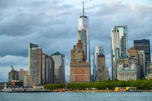 Manhattan skyline at dusk. Manhattan's skyline is highlighted by tall buildings and a calm waterfront under a moody sky in the early evening. photo