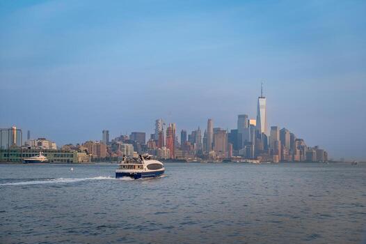 View of Manhattan skyline with ferry on the river. A passenger ferry sails across the river with Manhattan skyline in the background. photo