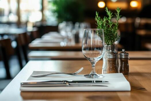 Table setting with glass silverware and plant in a restaurant area photo