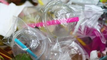 Plastic waste with cups and straws showing pollution and environmental problems, recycle and ecology issue for awareness background, close-up video