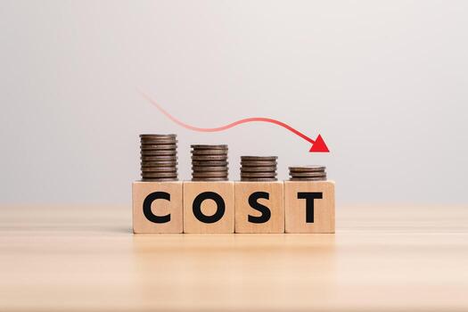 Concept of cost reduction in business finance with wooden blocks spelling COST placed on descending stacks of coins, red downward arrow, symbolizing decreasing expenses, saving strategy, efficien photo