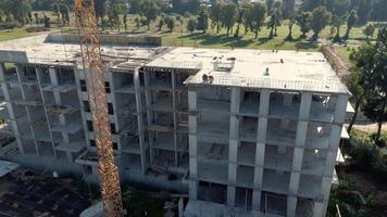 mång våning förstärkt betong byggnad under konstruktion med kran, arbetare synlig på tak och utsatt ramverk som visar framsteg av urban projekt video