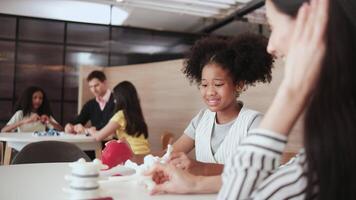 Group of student girls brainstorm and discuss with their teachers' tables in science lesson, playful learning in primary class together, studying kids' knowledge at elementary international school. video