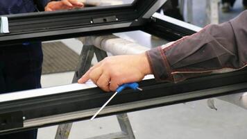 arbetstagare montering en fönster ram i en fabrik video