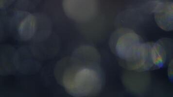 Dreamy bokeh lights with rainbow prisms create a magical, ethereal glow on dark background video