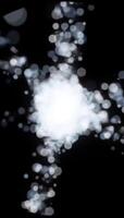 dynamisk vertikal animering av en ljus vit partikel explosion strålande utåt från en central brista på en mörk bakgrund video