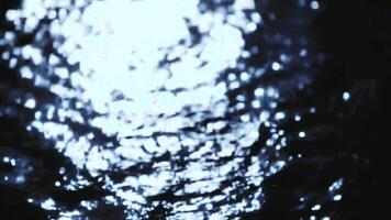 abstrakt långsam rörelse av skimrande månsken reflekterande på en mörk vatten yta skapande en lugn och mystisk humör video