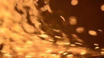 estremo vicino su di ardente scintille volante e raggiante nel un' mulinello movimento su un' buio sfondo la creazione di un' caldo astratto effetto video
