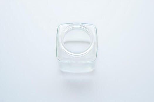Top Down View of an Empty Square Glass Jar on a White Surface photo