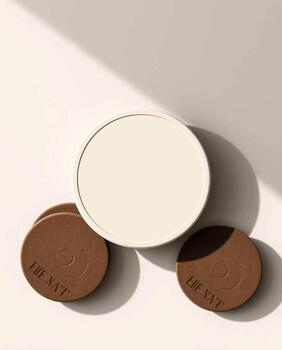 Minimalist arrangement of round flat objects casting soft shadows on a neutral background with diagonal light photo