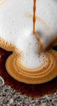 cerca arriba de espumoso café siendo vertido creando un arremolinándose modelo en un texturizado superficie foto