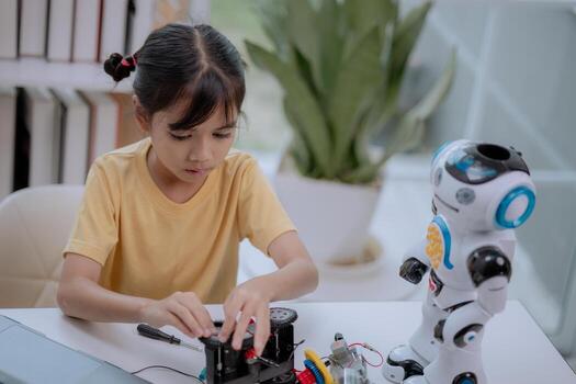 Asian girl assembling robot car with toy robot beside her, learning STEM education and robotics technology. Concept of child creativity, engineering, innovation and future digital learning. photo