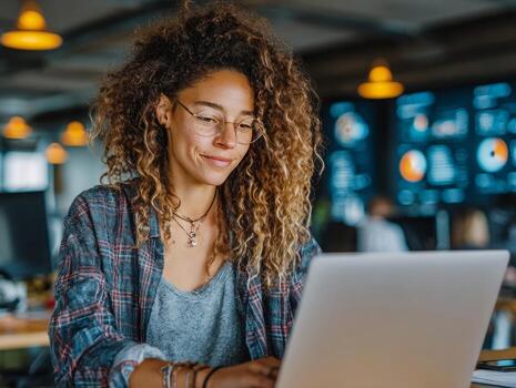 sonriente computadora programador trabajando en ordenador portátil en moderno oficina con cartas en pantalla foto