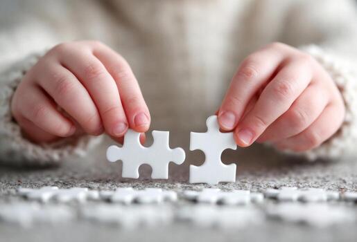 Child hands connecting white jigsaw puzzle pieces photo
