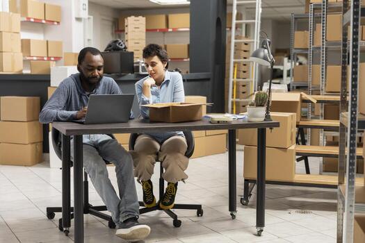 Two employees navigate order fulfillment and inventory management, shipping area of this small business highlights teamwork and operational efficiency. In house product handling. photo