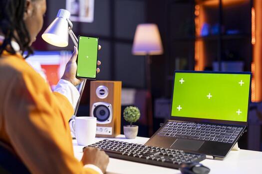 Student at desk using isolated screen notebook and mobile phone, browsing internet, researching information online. Girl reading articles on mockup laptop and cellphone for school tasks photo