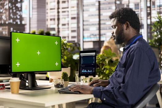 African american analyst finalizing a report with data analytics next to copy space, developing a project for company development. Professional employee engaged in task management at desk. photo
