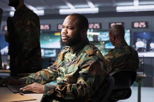 Officer in war room planning, analyzing and gathering information on enemy troops. Intelligence agency operative in base of operations doing assessment of adversaries capabilities and vulnerabilities photo