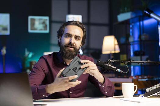 Tech content creator filming technology review of newly released V mount battery, unhappy with its performance. Media star dissatisfied with charging device, giving it low rating photo