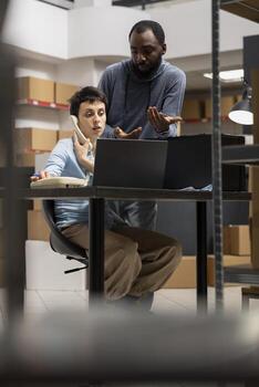 Diverse team uses inventory room logistics for order processing, coordinating logistics in a small warehouse. Solving business operations and tasks of a local delivery company. photo