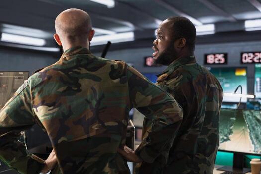 Military officer and colleague operating high tech aerial systems to support reconnaissance and target identification. Team of army specialists monitoring counterinsurgency attacks photo