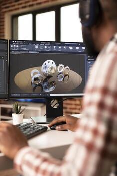 Black male engineer working on construction machinery prototype using CAD software in modern home studio. Desktop monitor displays technical interface and precision modeling tools. photo