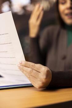 Mature woman focused on university level reading and studying, surrounded by textbooks and documents in a calm quiet study area designed for academic preparation and reflection. Close up. photo
