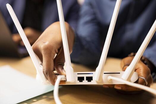 African American couple struggling to fix an error from their Wi Fi modem, troubleshooting by pulling out the LAN cable for a restart. Slow internet decreases remote job efficiency. Close up. photo