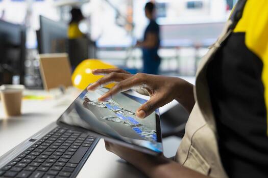 Black engineer running diagnostic checks on solar panel assembly software, optimizing the production process and solar cells for alternative energy. Industrial factory finetuning. photo