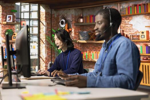 Multiethnic customer service colleagues tracking support ticket in dedicated company software on PC. Multiracial workers in diverse call center office creating support ticket for customer calling photo