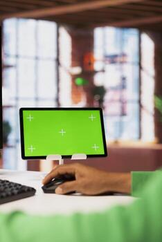 Man at home using isolated screen tablet to browse social media website, looking at memes. Person in apartment looking at funny content online on mockup device, close up shot photo