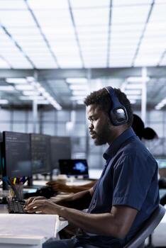 System administrator reconfiguring server farm to optimize it for data processing requirements of customers. IT professional working to ensure data center gear operates efficiently photo