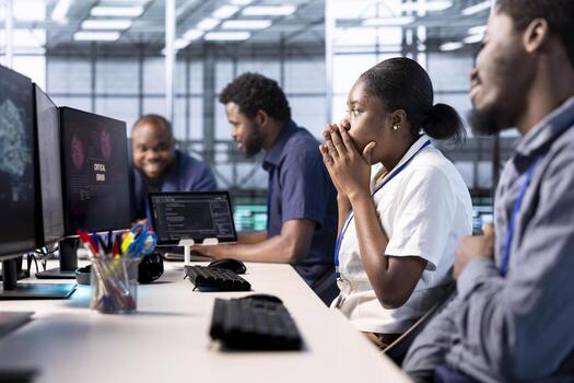 Engineer in server farm frightened by hacker passing firewall and stealing data. Security breach notification on monitor in data center scaring woman, requesting help from colleagues photo