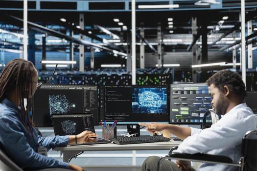 Data center engineer in wheelchair and coworker using AI visualization to oversee automated tasks. Worker with disability in inclusive server farm and colleague modifying systems based on analytics photo