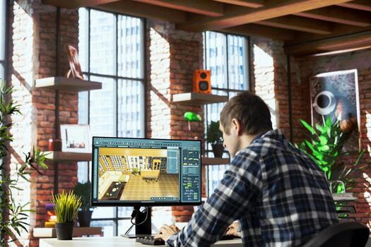 Freelancer working from home at workstation uses 3D modeling program, selecting furniture from catalog, dragging objects across floor plan. Man using CAD software, arranging layout, positioning items photo