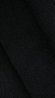 svart skinna tyg i rörelse tillverkad och animerad mjukt, sömlös textil- bakgrund för elegant design använda sig av video