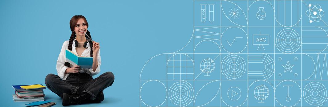 A student sits on the floor surrounded by books, holding a notebook and a pencil. With a thoughtful expression, she appears focused on her studies, ready to learn in a vibrant setting. photo