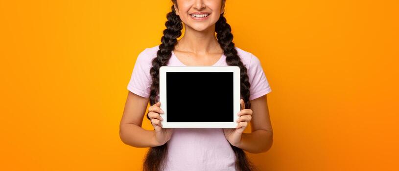 Great Application. Smiling Indian Lady Showing Tablet Computer With Empty Screen To Camera Recommending New App Posing Standing Over Yellow Studio Background. Digital Tablet Display Mockup For Advert photo