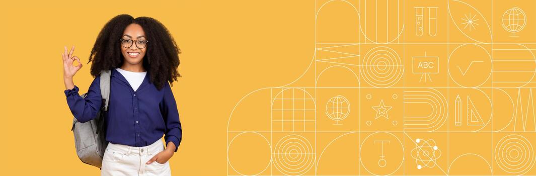 A cheerful student with curly hair and glasses stands with a backpack, making a hand gesture while studying in a brightly colored educational setting. The space emphasizes learning and creativity. photo