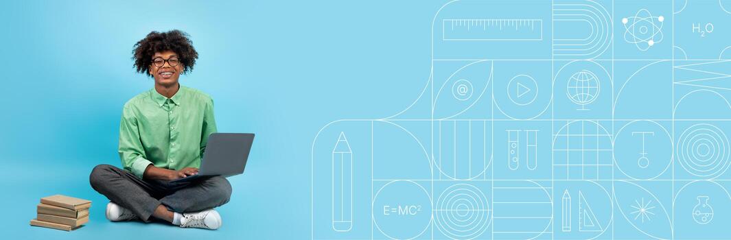 A student sits cross-legged on the floor, engaged with a laptop while studying. Surrounding them are stacks of books. photo