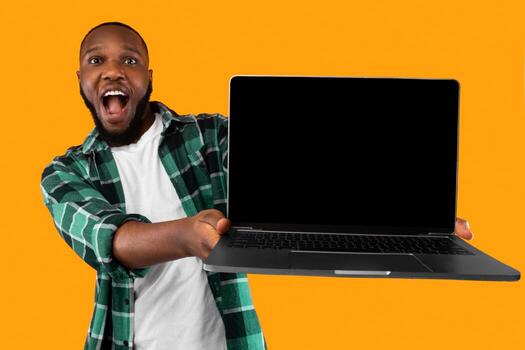 Excited Black Guy Showing Big Laptop With Empty Screen Recommending Website And Advertising Online Service Posing On Yellow Background. Studio Shot. Advertisement With Computer Monitor Mockup photo
