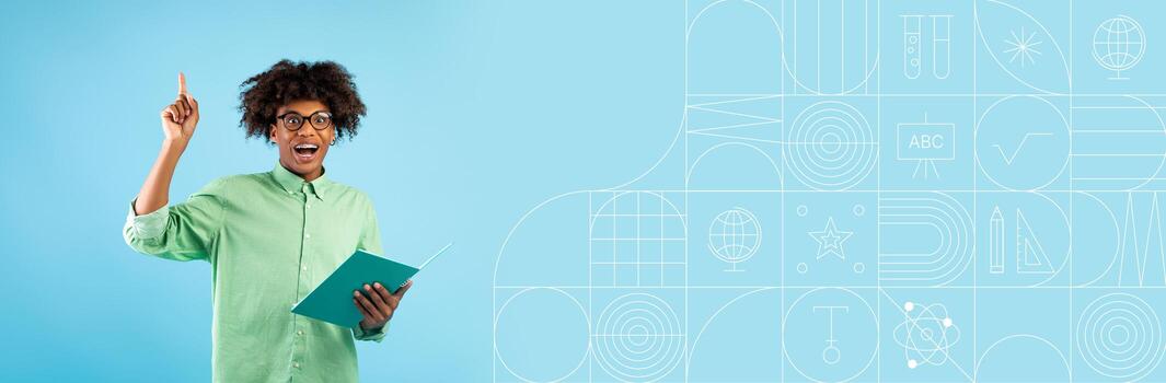 A student with an excited expression holds a notebook while pointing upwards, indicating a moment of insight. photo