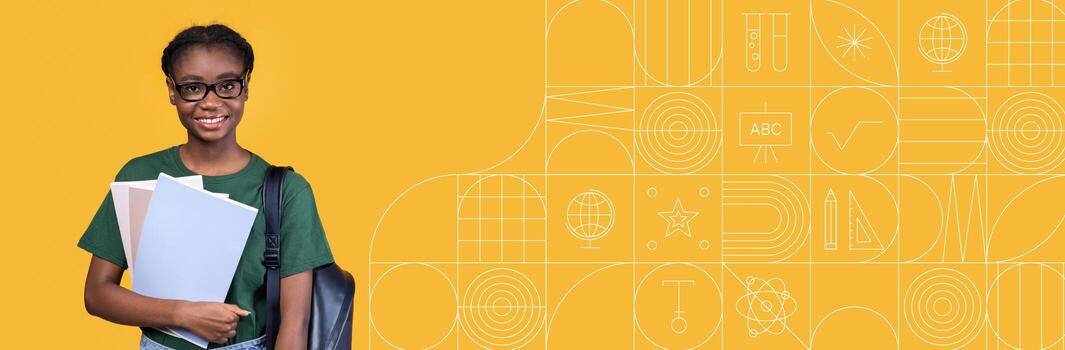 A young student stands confidently, holding several books and studying materials in front of a bright yellow backdrop filled with educational icons. The setting conveys a focus on learning and growth. photo