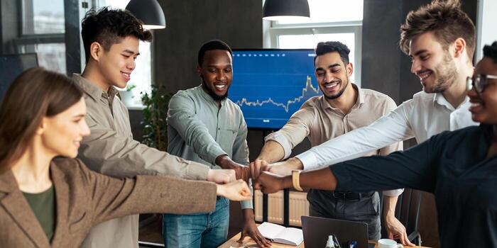Success And Connection Concept. Smiling multiracial group of diverse business people making fist bump standing in circle. Happy colleagues pumping hands together as symbol of unity and achievement photo
