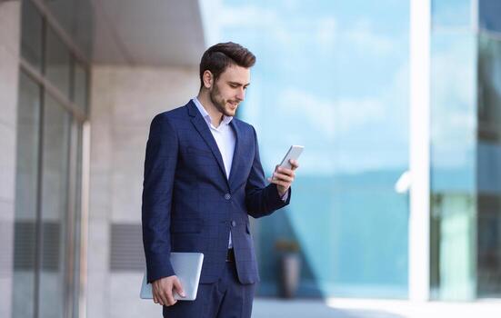 Professional entrepreneur with tablet computer using smartphone near office building at modern metropolis, copy space photo